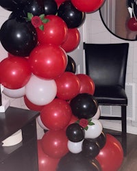 a balloon arch decorated with red, black and white balloons