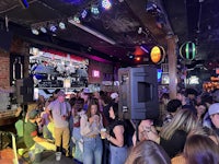a crowd of people standing in a bar