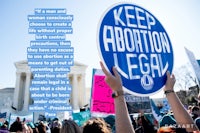 a group of people holding up a sign that says keep abortion legal