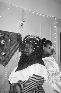 a black and white photo of two women dressed up in costumes