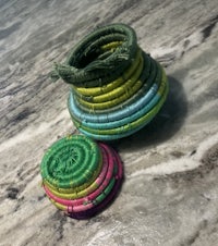 two colorful woven baskets sitting on a marble floor
