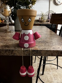 a wooden doll sitting on a counter in a kitchen
