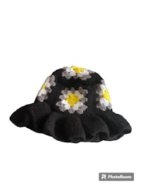 a black and white crocheted hat with yellow and white flowers