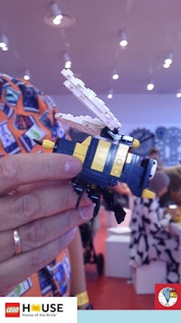 a person holding a lego bee at a convention