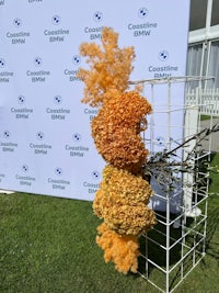 a large arrangement of orange flowers on a stand