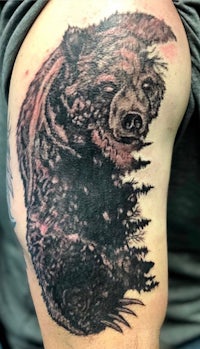 a bear tattoo on a man's arm