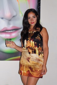 a woman in a dress posing in front of a painting