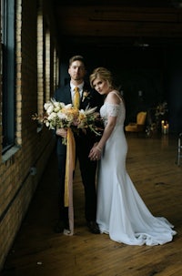 a bride and groom posing in an old warehouse