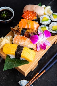 japanese sushi on a wooden tray with chopsticks