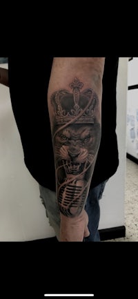 a man with a tattoo of a tiger on his forearm