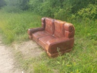 an old couch sitting on the side of the road