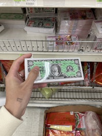 a person holding a dollar bill in a store
