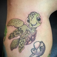 a tattoo of a turtle on a person's thigh