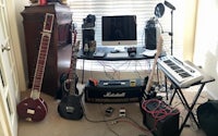 a room with guitars, keyboards, and other equipment