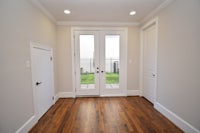 a hallway with white doors and hardwood floors