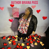 author brianna pass holding a book in front of hearts