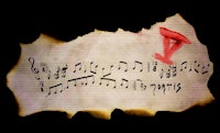 a sheet of music with a red note on it