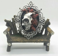 an ornate skull is sitting on a wooden bench