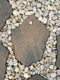 a circular pattern of rocks and pebbles in a garden