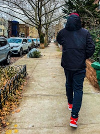 a man walking down a sidewalk with a skateboard