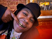 a man wearing a hat and a hat with gold teeth