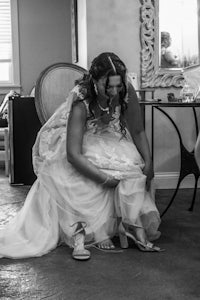 a bride putting on her wedding shoes