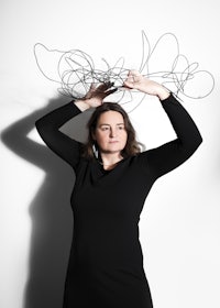 a woman holding up a bunch of wires on her head