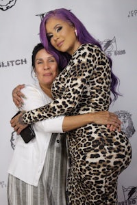 two women hugging each other on a red carpet