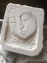 a piece of clay with a face on it
