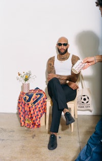 a man with tattoos sitting on a chair