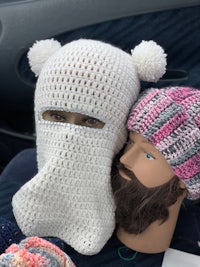 two mannequins sitting in a car with knitted hats