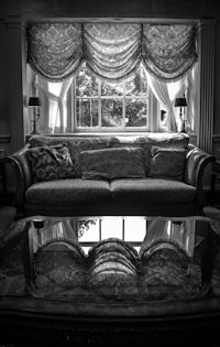 a black and white photo of a couch in a living room