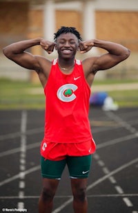 a young man posing for a photo on a track