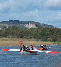a group of people rowing a boat