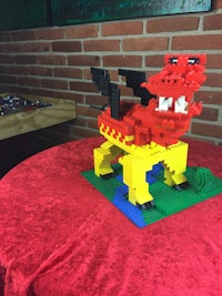 a lego dragon sitting on top of a red table