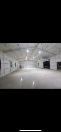 a large warehouse with a white floor and lights