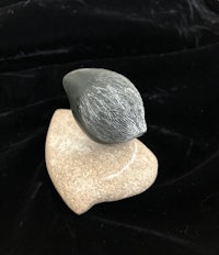 a small stone sculpture on top of a black cloth