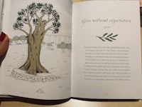 an open book with an illustration of a tree