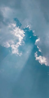 rays of light shining through clouds in a blue sky