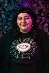 a woman wearing a black t - shirt with a spider web on it
