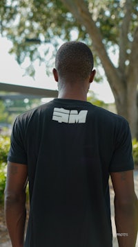 the back of a man wearing a black t - shirt