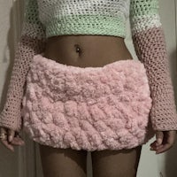 a woman wearing a pink crocheted skirt