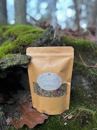 a bag of herbal tea sitting on top of moss in the woods