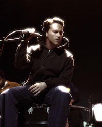 a man is sitting on a stool in front of a microphone