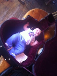 a baby laying in a guitar case