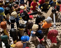 a large group of lego people gathered around a table