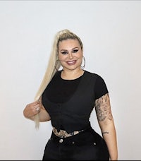 a woman in a black top and black pants posing for a photo