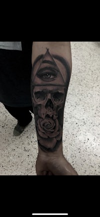 an all seeing eye tattoo on a man's forearm