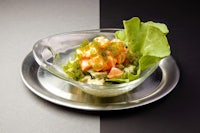 a salad on a plate with lettuce and salmon