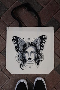 a tote bag with an image of a woman with a butterfly on it